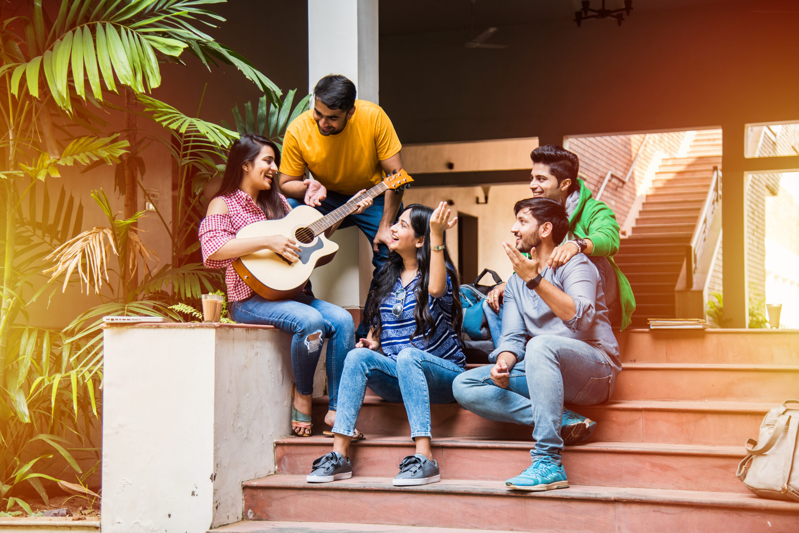 Asian,Indian,College,Students,Playing,Music,With,Guitar,While,Sitting